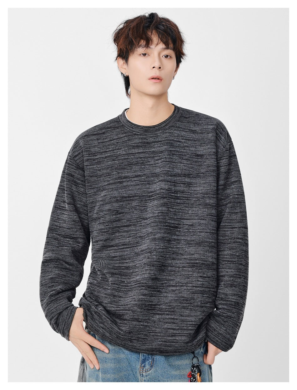 Model wearing a charcoal and gray marled long-sleeve crewneck sweatshirt.