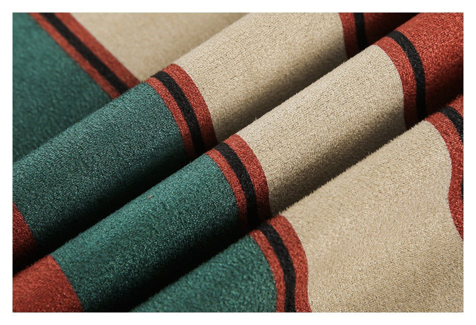 Close-up of folded rust-red, teal, cream, and black striped fabric with a textured surface.