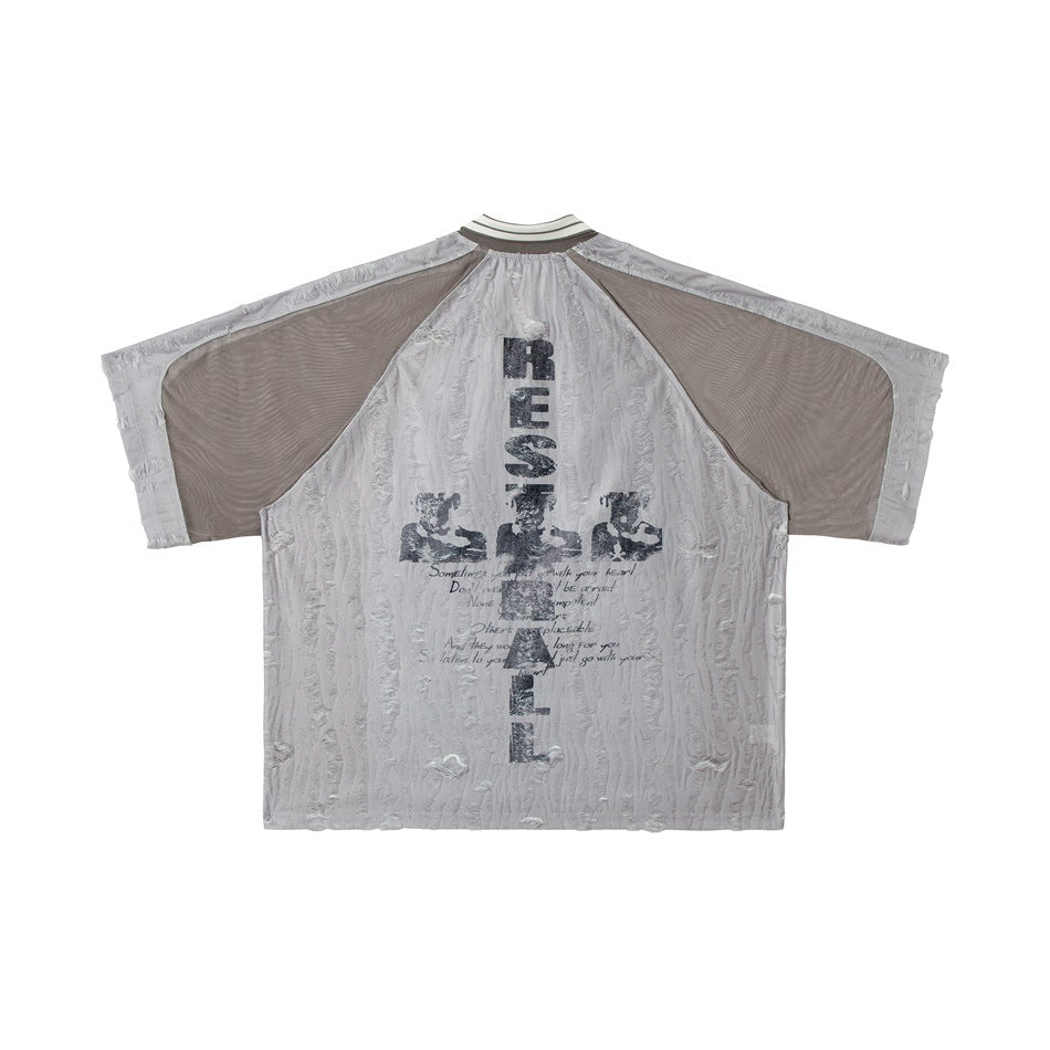 Back of a light gray short-sleeve collared top with taupe mesh panels and distressed black printed graphics and text.