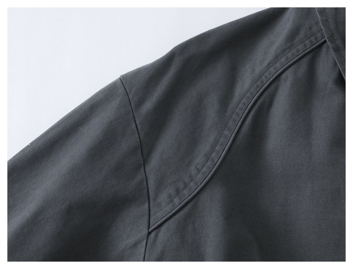 Close-up of the charcoal jacket’s shoulder and sleeve seams against a white background.