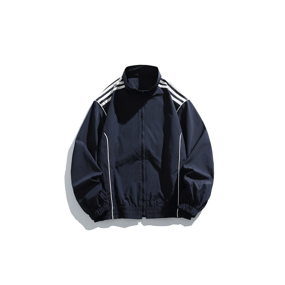 Navy stand-collar zip track jacket with white shoulder stripes, white piping and elastic cuffs and hem, flat lay front view
