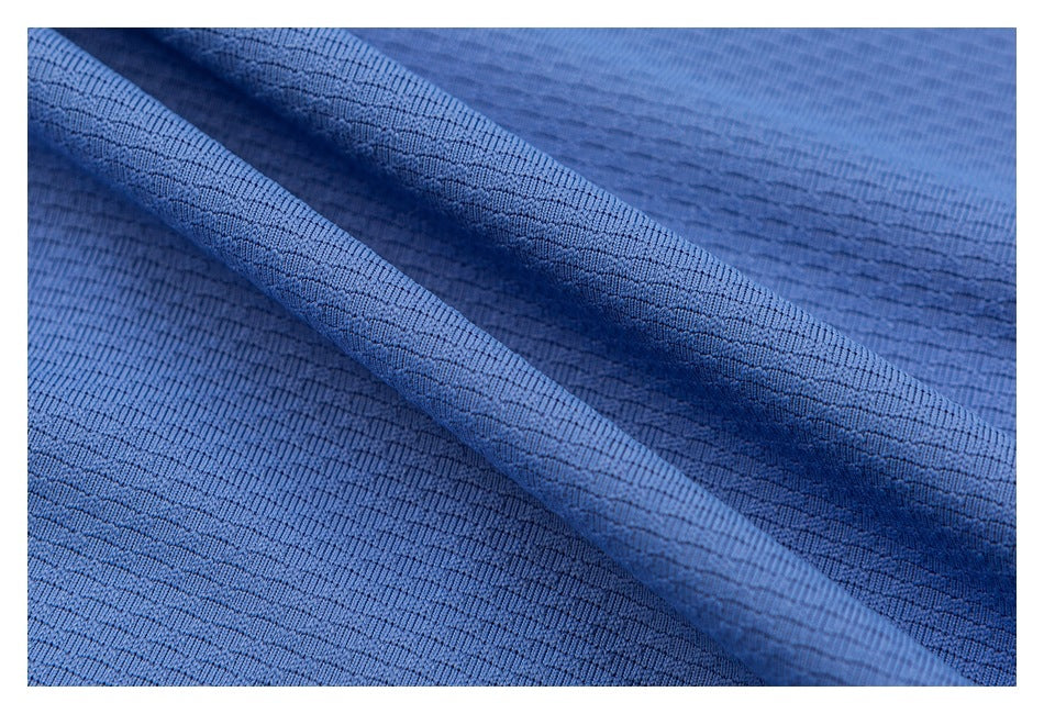 Close-up of blue garment fabric draped to show its fine textured surface.
