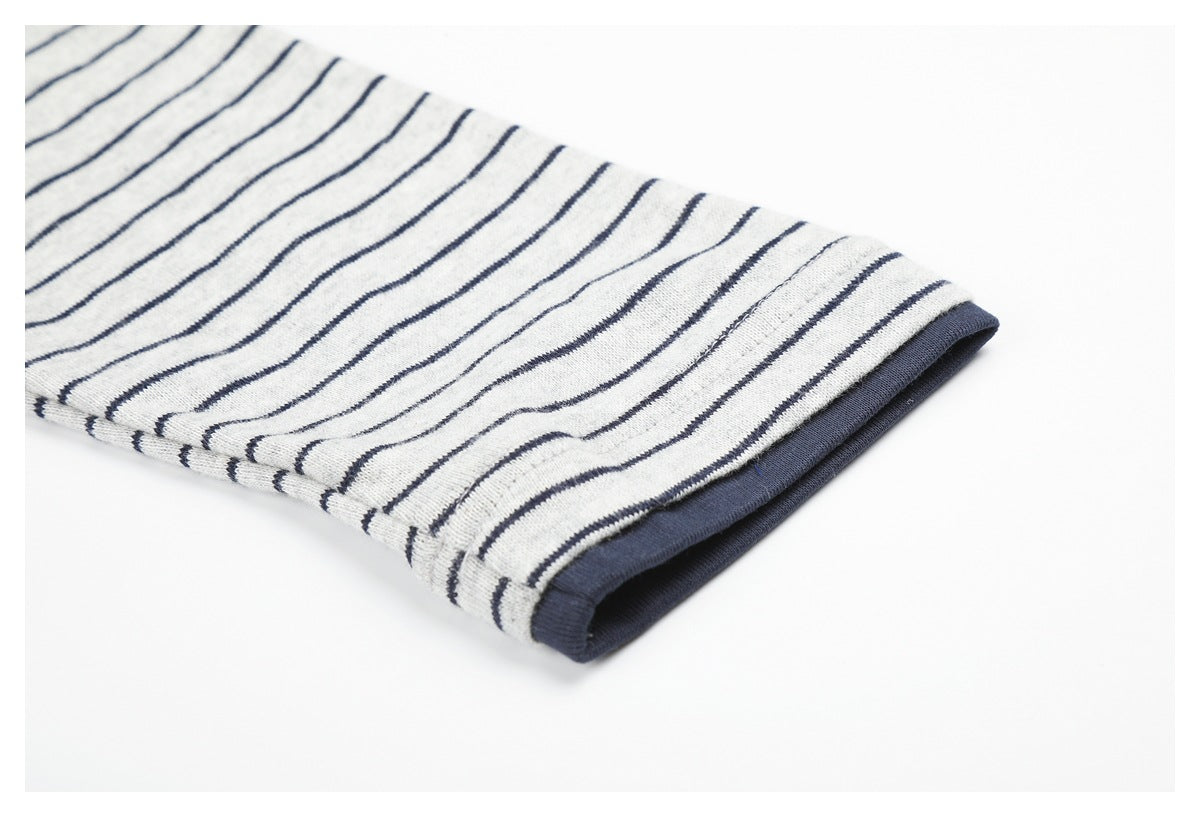 Close-up of a navy-edged opening on light gray fabric with thin navy stripes.