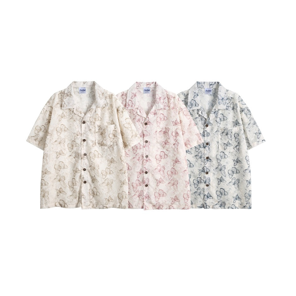 Three short-sleeve button-up shirts with butterfly prints in ivory, pale pink, and white with blue-gray.