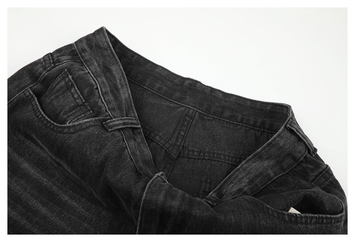 Close-up of the open waistband and belt loops of charcoal-black jeans, with the inner waist seam visible.