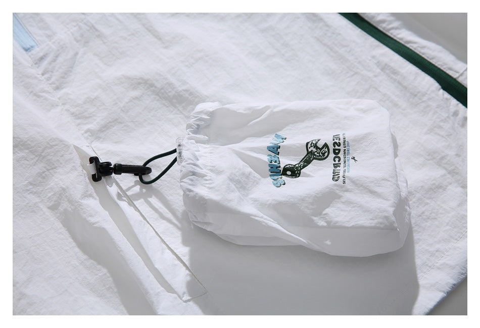 Close-up of a white jacket's attached pouch with blue and black printed English text and a graphic.