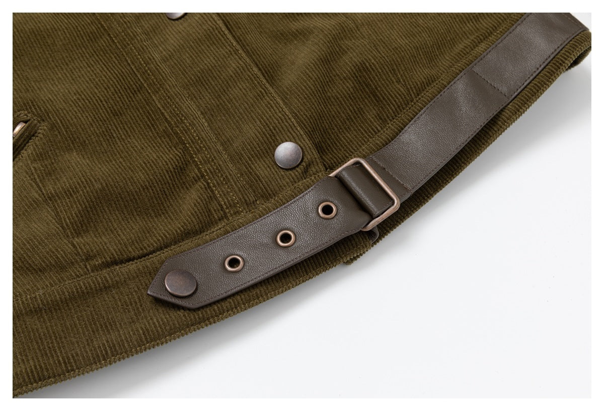 Close-up of an olive-brown corduroy garment with a dark brown adjustable strap, metal eyelets, buckle, and snap.