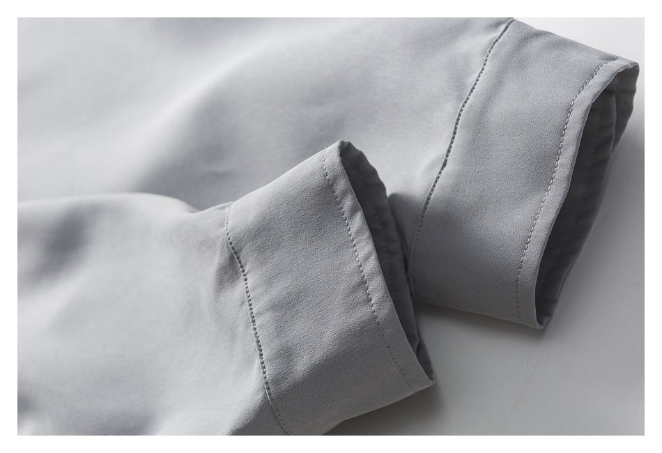 Close-up of two folded light gray sleeve cuffs with visible stitching.