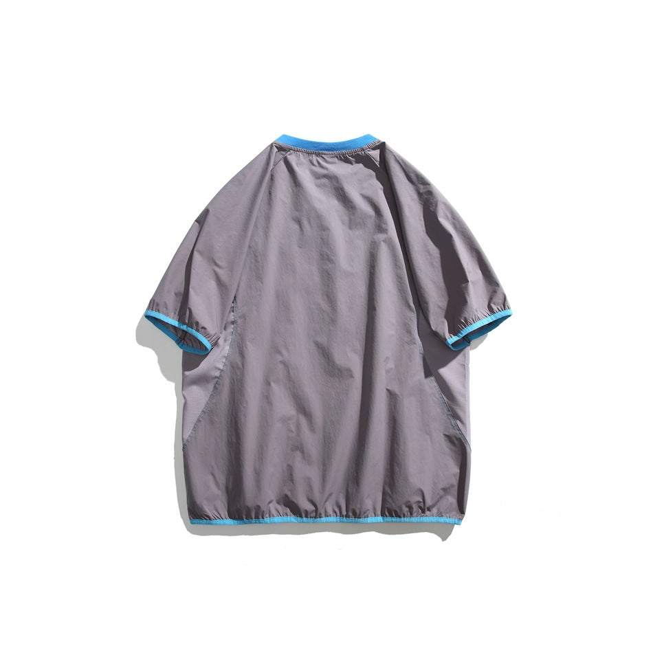 Back view of a gray short-sleeve shirt with bright blue trim at the collar, cuffs, and hem, laid flat.