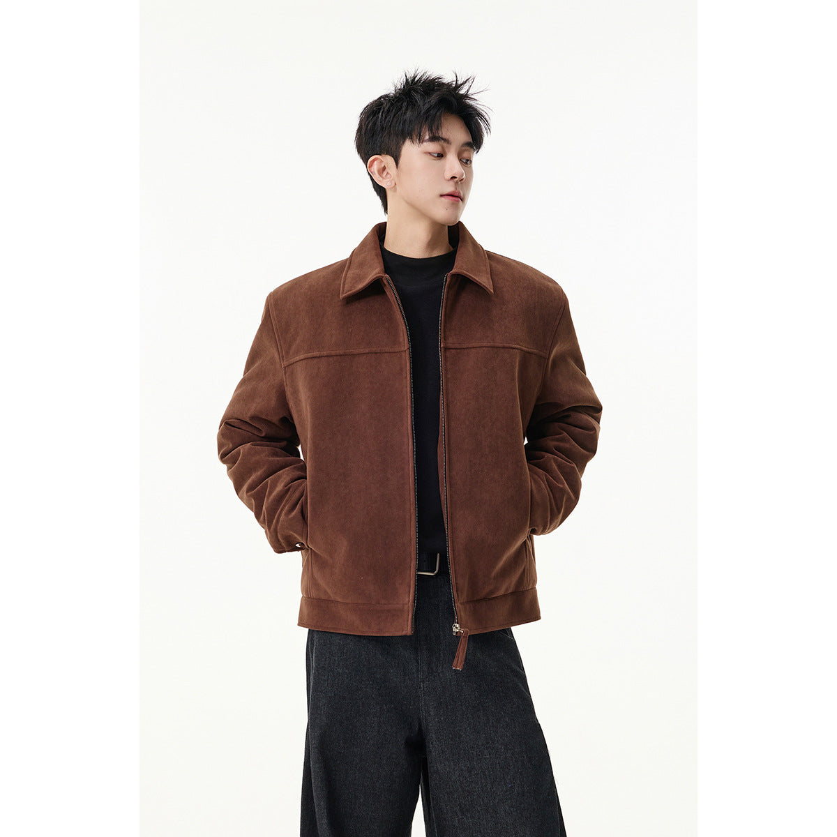 Model wearing a brown collared zip jacket over a black top and dark trousers.