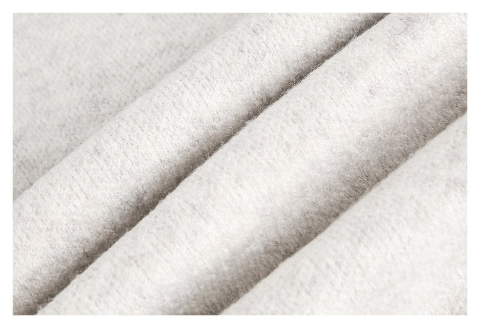 Macro view of the soft, fuzzy ivory knit texture on a sweater.