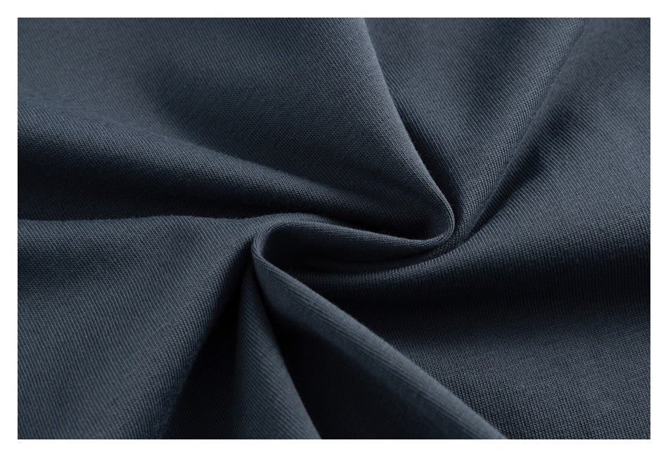 Close-up of dark charcoal fabric gathered into soft folds, showing a fine ribbed knit texture.