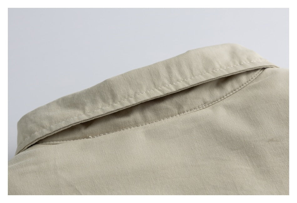 Close-up of a beige garment collar showing its folded edge and stitching.