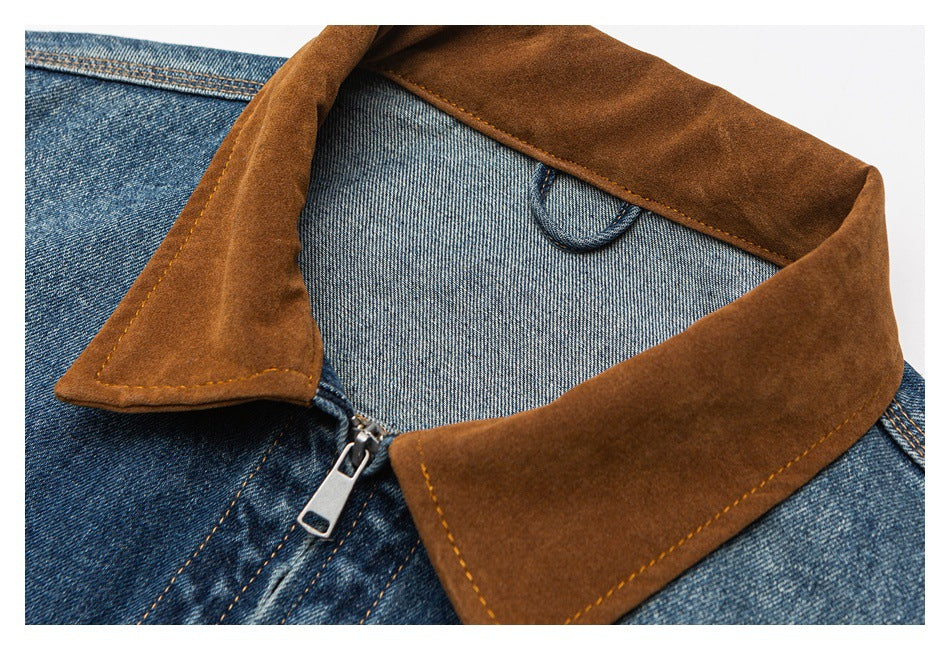 Close-up of a blue denim jacket with a brown contrast collar, visible stitching, and a metal zipper.