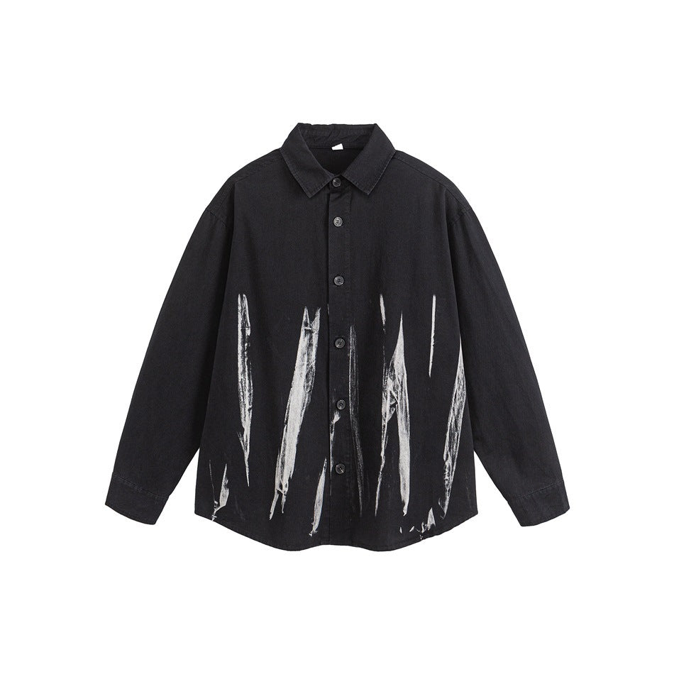 Black long-sleeve button-up shirt with white brushstroke marks on the lower front, flat lay