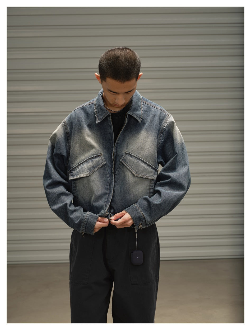 Closer front view of a model wearing a faded blue denim jacket with a pointed collar and flap chest pockets.