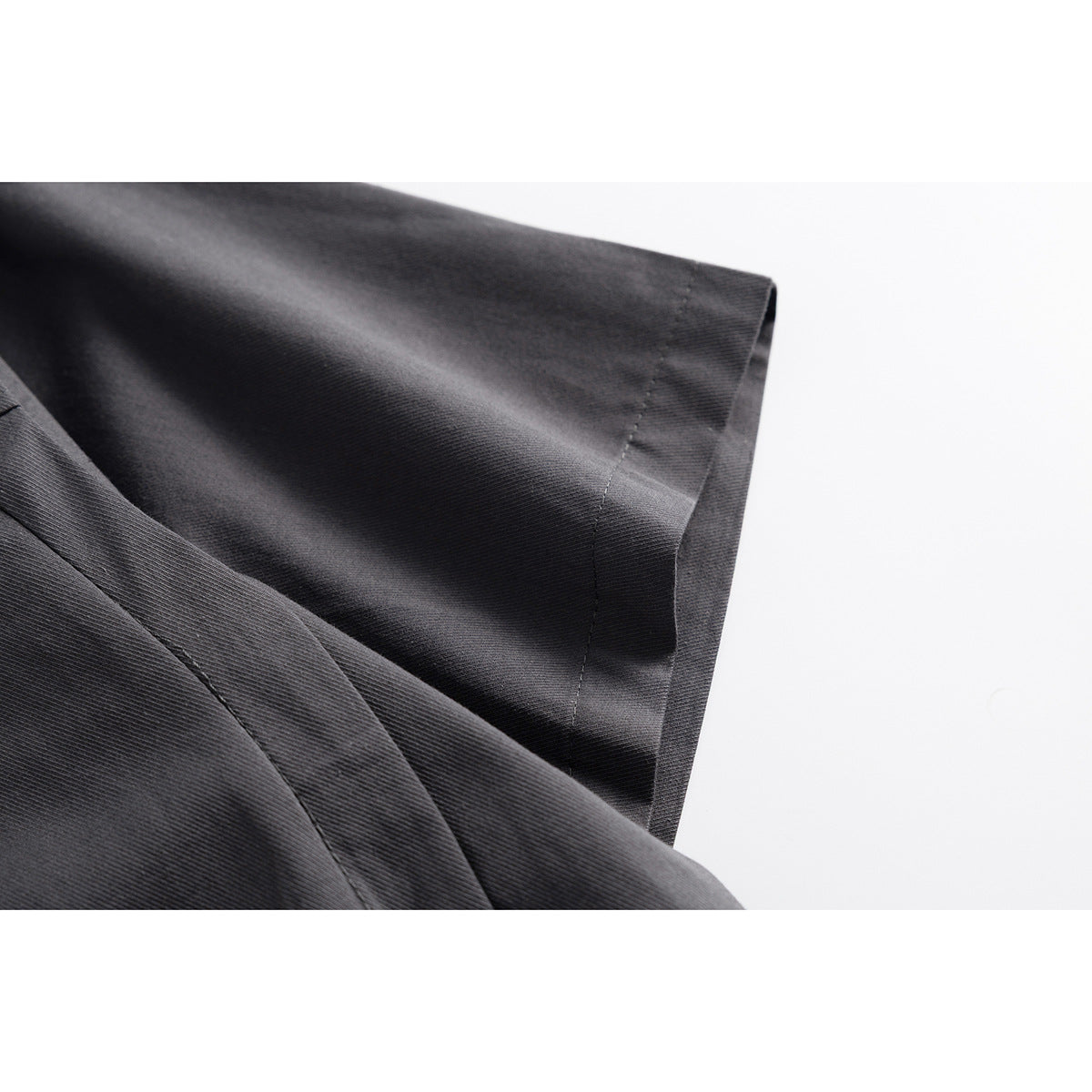Close-up of the charcoal shirt's short sleeve and stitched hem.