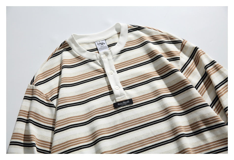 Cropped front view of an ivory shirt with tan and black stripes, a white collar, and a three-button placket.