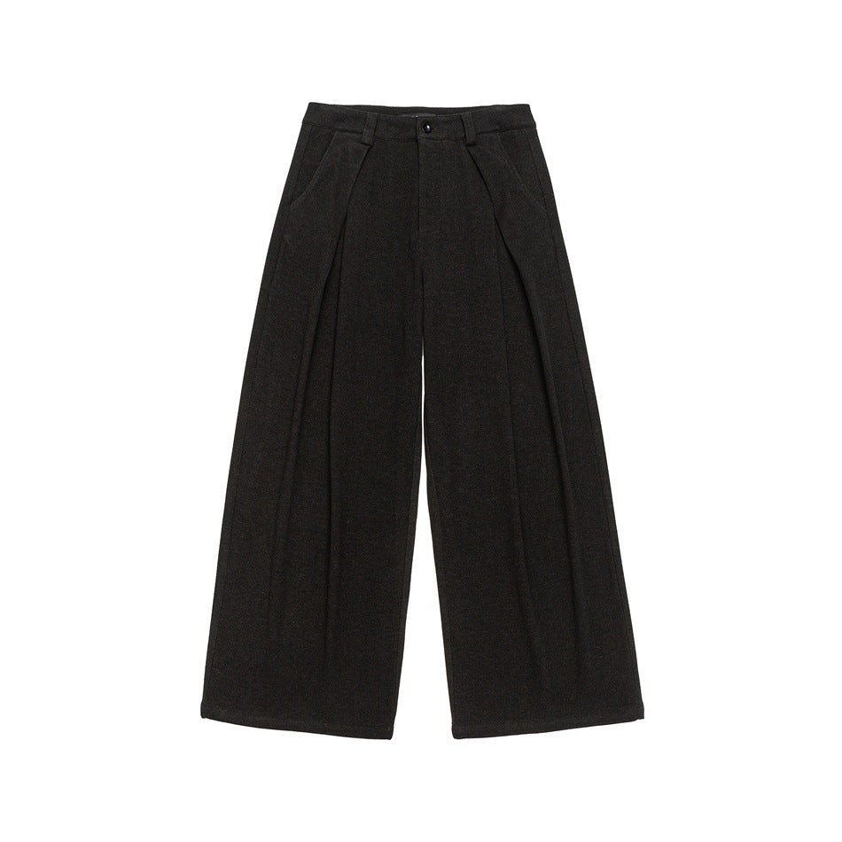 Front view of dark charcoal wide-leg trousers with front pleats, slanted pockets, belt loops and a button closure.