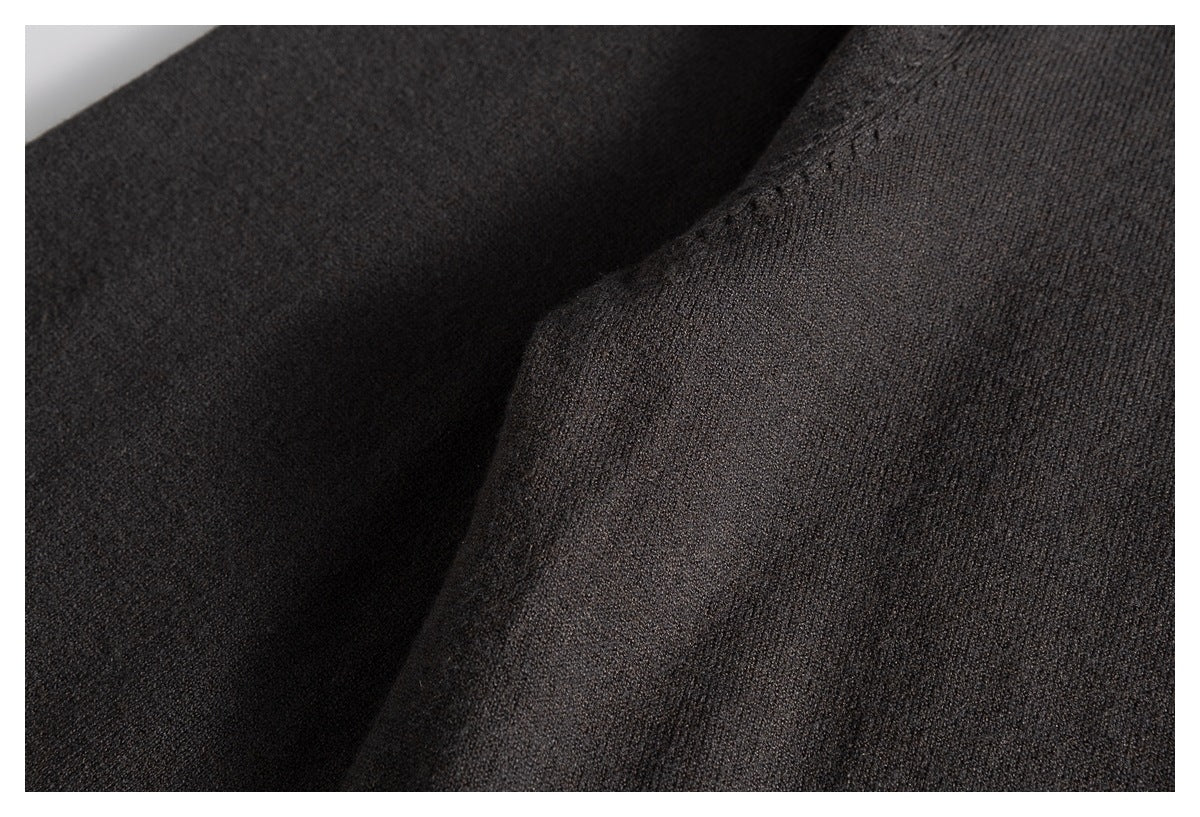 Close-up of the charcoal sweater's fine knit texture and draped fabric.