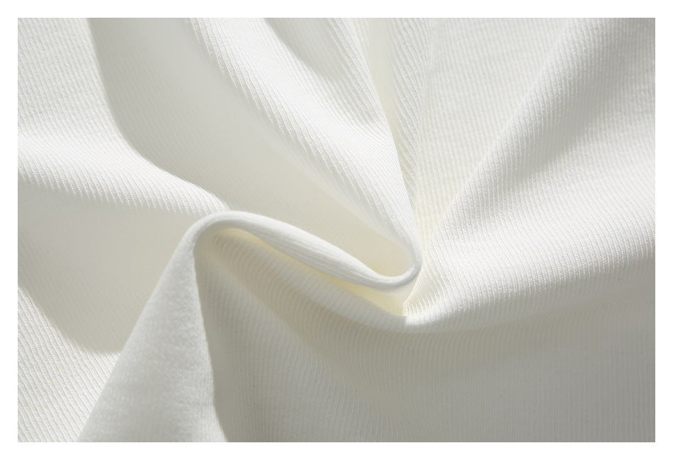 Extreme close-up of white ribbed fabric gathered into soft folds.