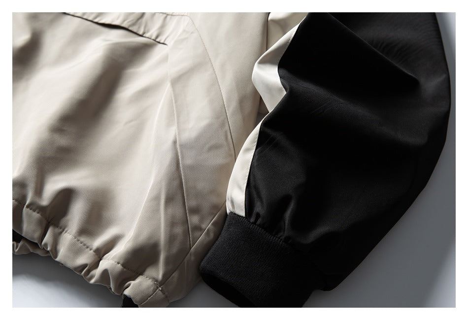 Close-up of a jacket’s light taupe body and black sleeve with a ribbed cuff.