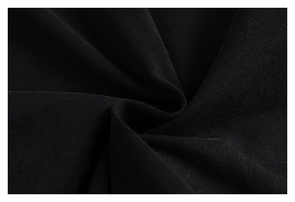 Close-up of black fabric draped into soft folds, showing its surface texture.