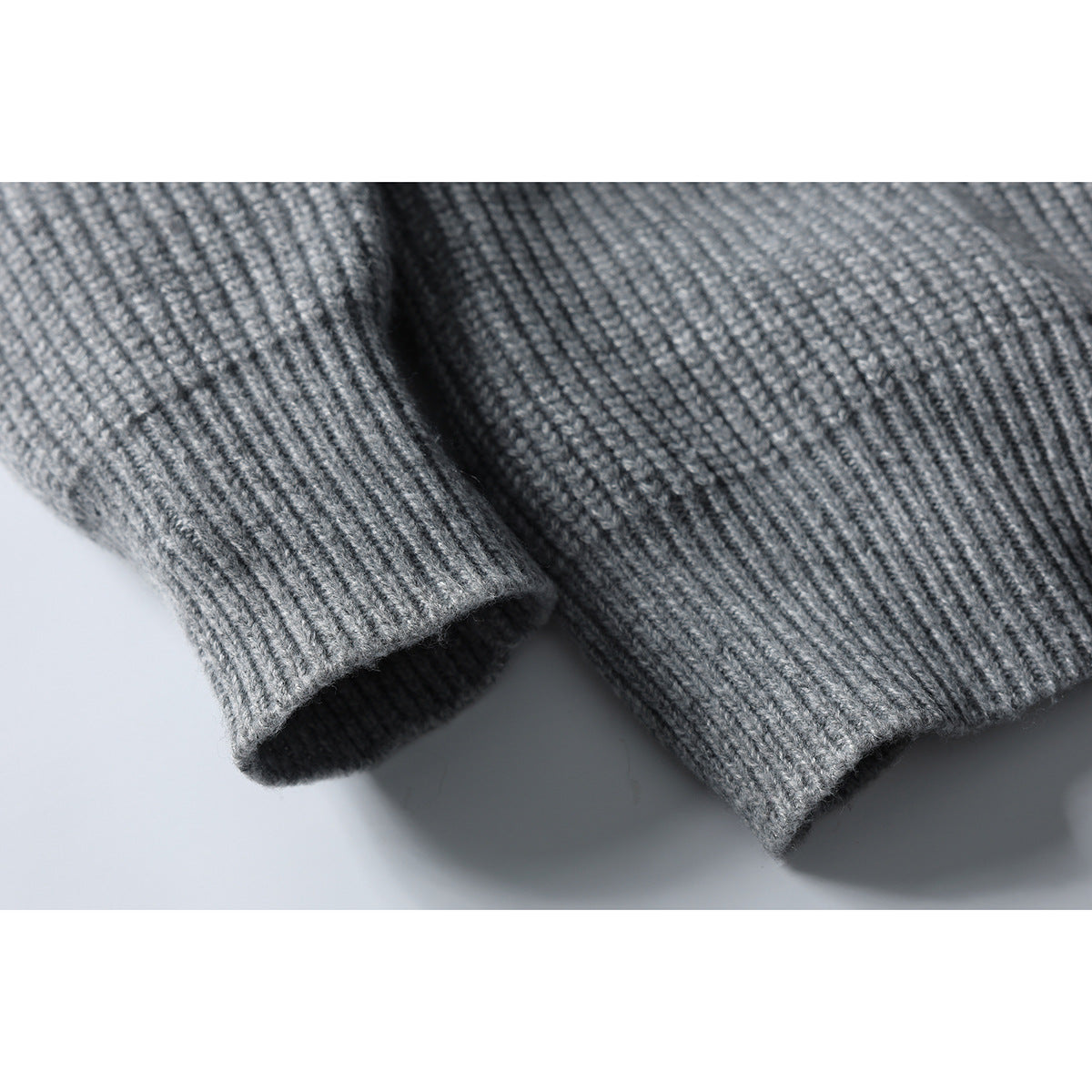 Close-up of the gray rib-knit sweater's sleeve cuff and ribbed hem.