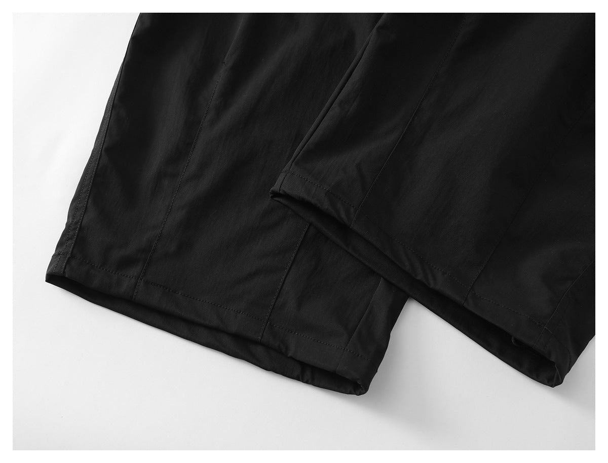 Close-up of the straight hems and stitching on black pants.