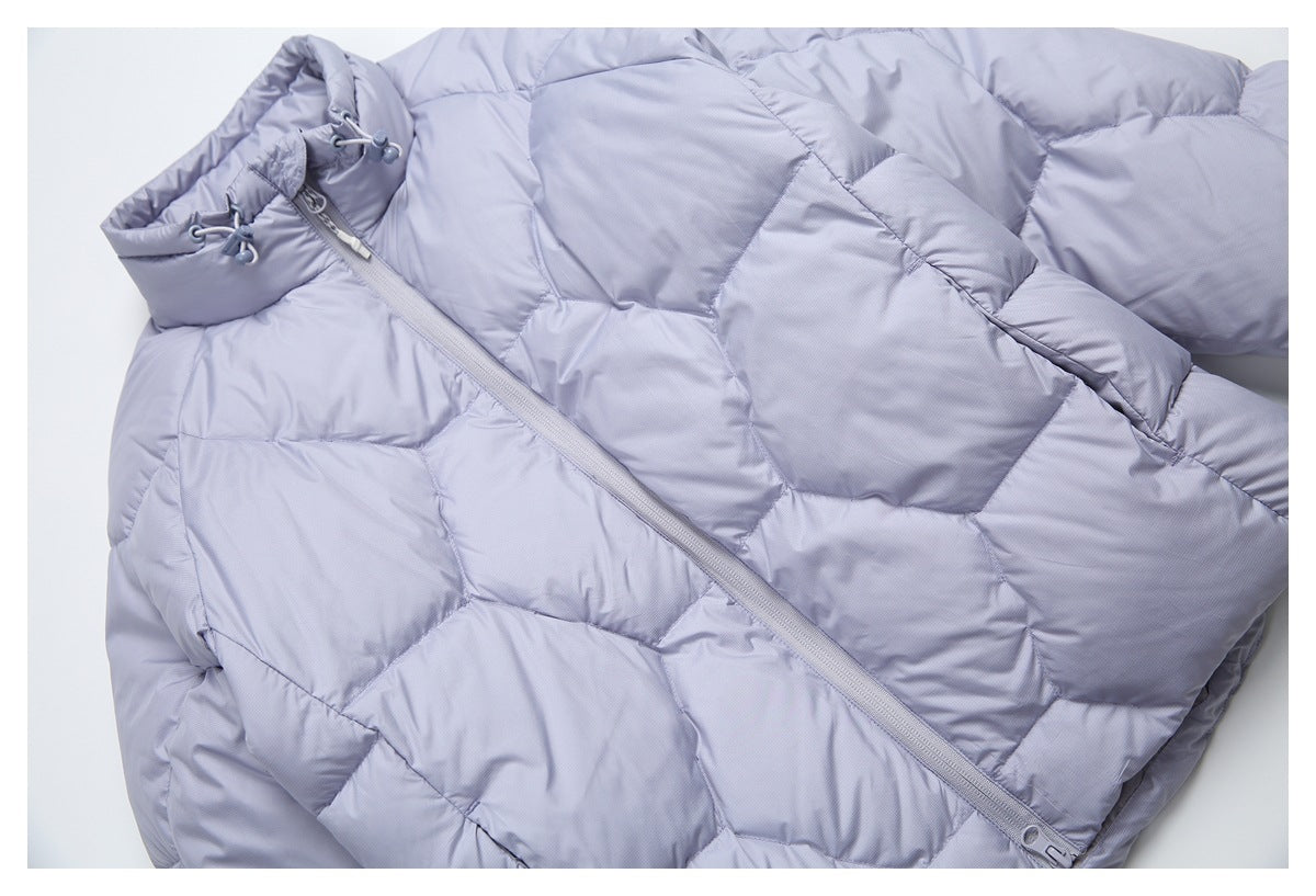 Close-up of a pale lavender puffer jacket with geometric quilting and a diagonal front zipper.
