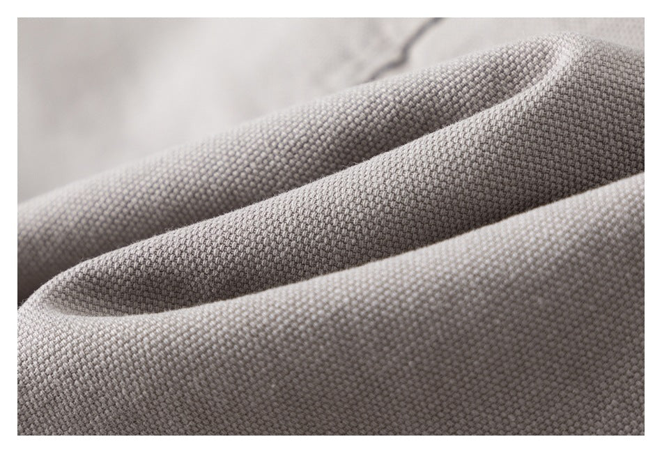 Close-up of light gray-beige fabric showing a dense, small-scale woven texture.