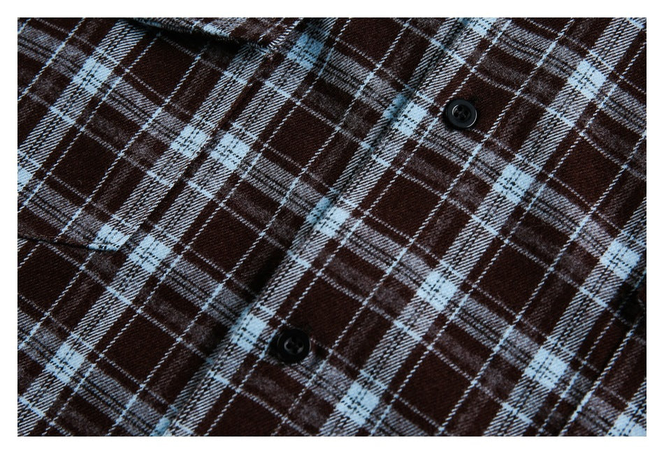 Close-up of a dark brown plaid shirt with pale blue and white lines and black buttons.