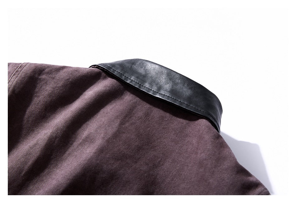 Close-up of a black leather-look collar or trim over dark mauve-brown fabric.