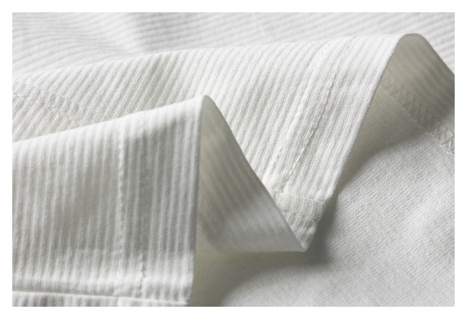 Close-up of a folded white ribbed knit edge with visible stitching.
