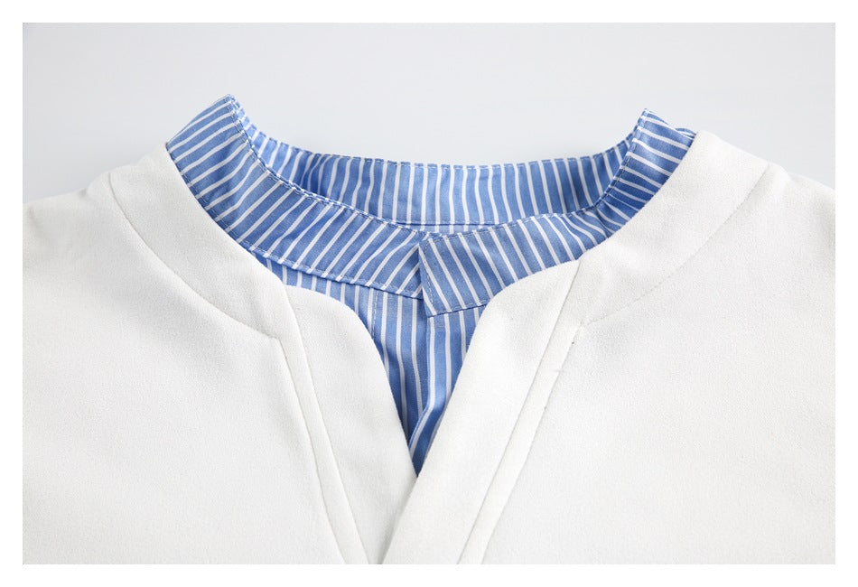 Close-up of a white garment's V-neck and blue-and-white striped collar and inner placket.