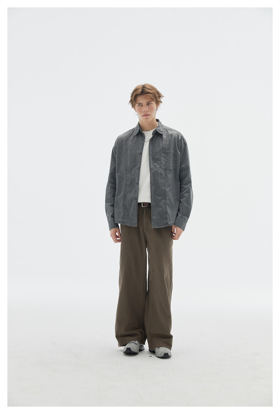 Front view of a model wearing a charcoal button-up shirt over a white T-shirt with dark olive wide-leg trousers.