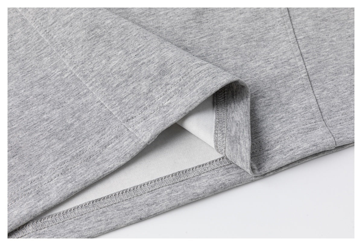 Close-up of the inside stitching and overlocked seam at the hem of a heather-gray T-shirt.