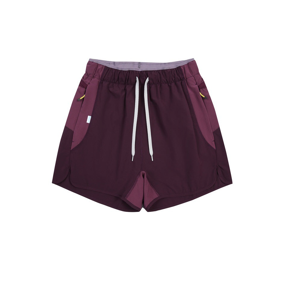 Dark purple drawstring shorts with lighter purple side panels, flat lay front view