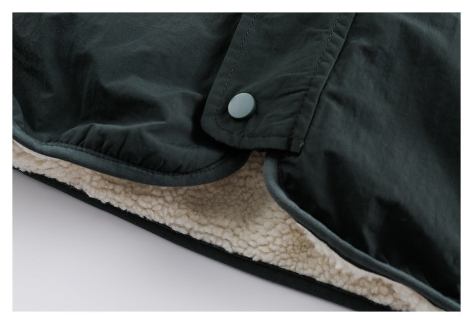 Close-up of a dark jacket snap-button flap and cream sherpa lining along the edge.