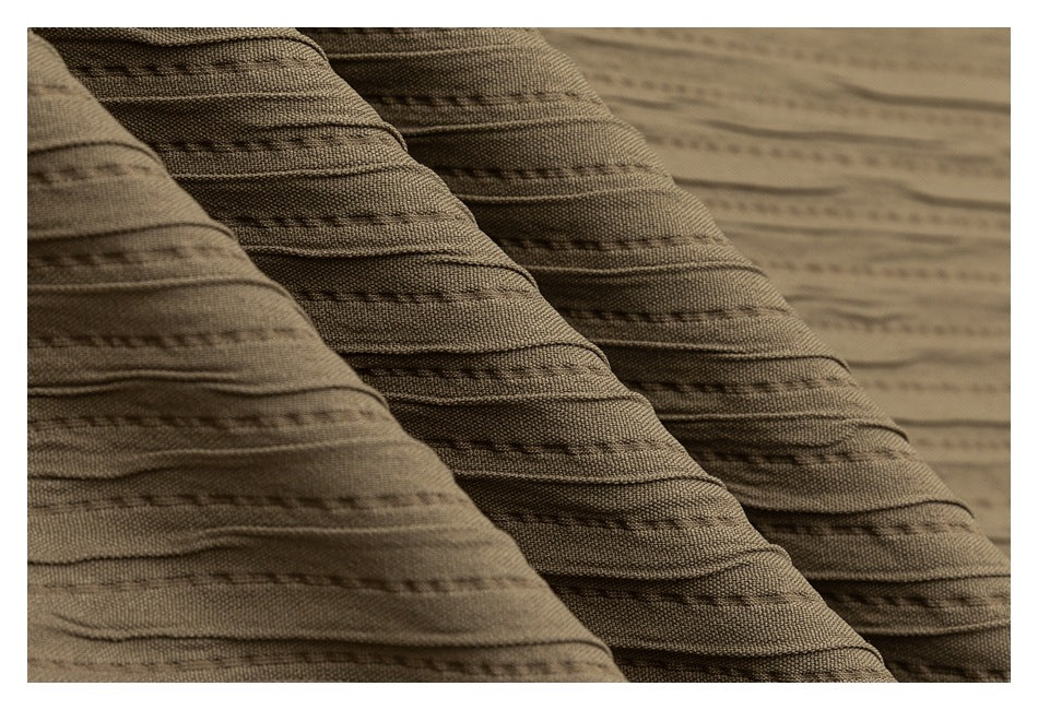 Macro view of the taupe fabric's raised horizontal ridges and dark stitched rows.