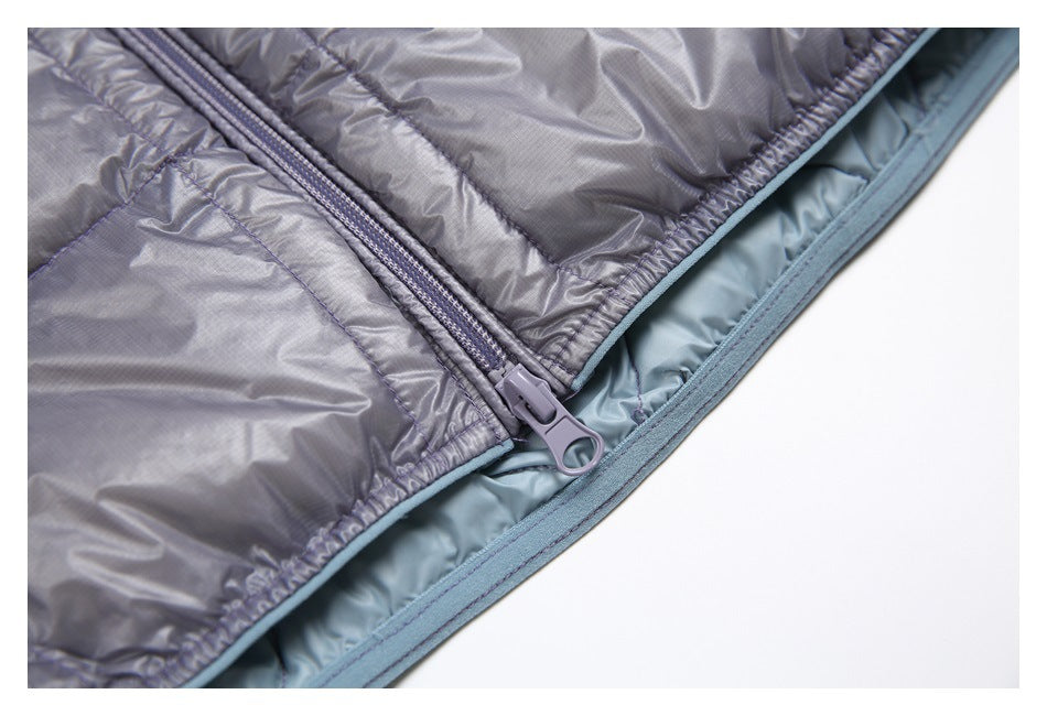 Close-up of the gray jacket's front zipper near the hem, with blue trim and lining visible.