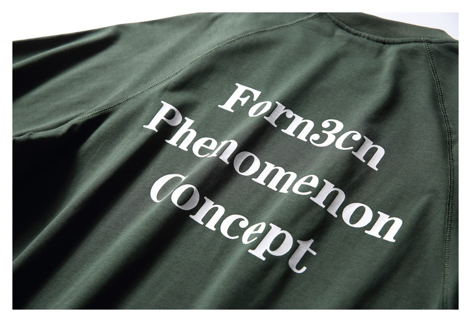 Angled close-up of large white “Forn3cn Phenomenon Concept” lettering on the dark green shirt back.