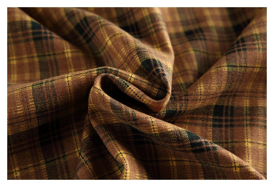 Close-up of brown, mustard, and dark green plaid fabric gathered into soft folds.