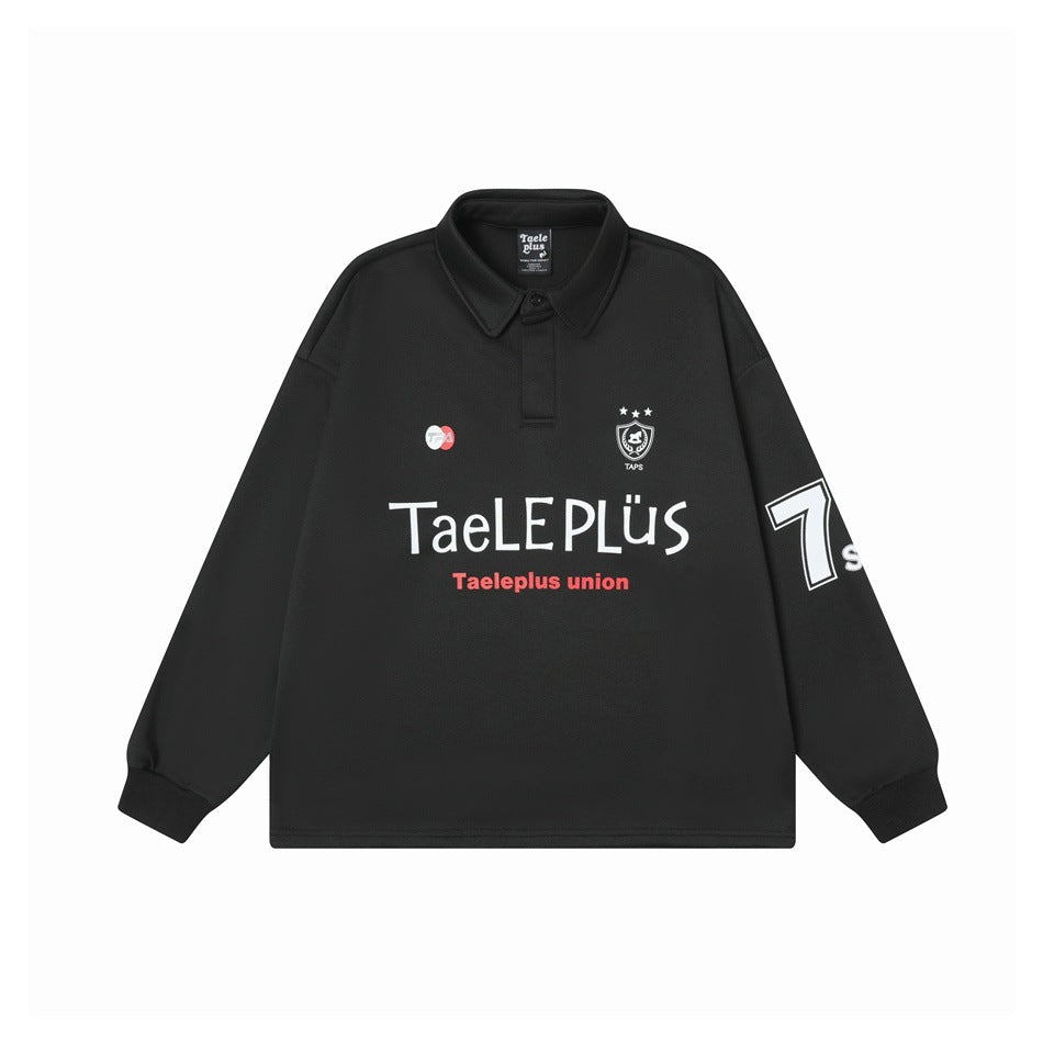 Front view of a black long-sleeve polo with a collar, chest graphics, and a large outlined 7 on the sleeve.