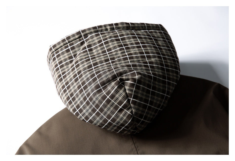 Close-up of the brown jacket's hood, showing a dark plaid lining.