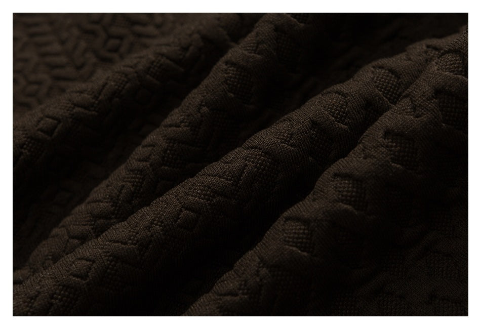 Close-up of dark brown fabric with a raised geometric pattern and textured surface.