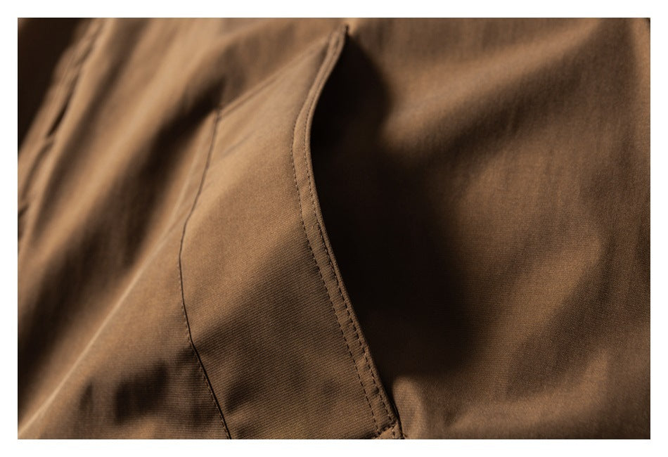 Close-up of a brown jacket pocket opening and stitched edge.