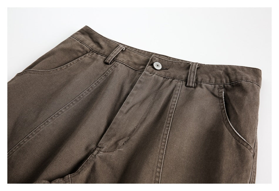 Close-up of the pants' front waistband, button, belt loops, and curved pocket openings.