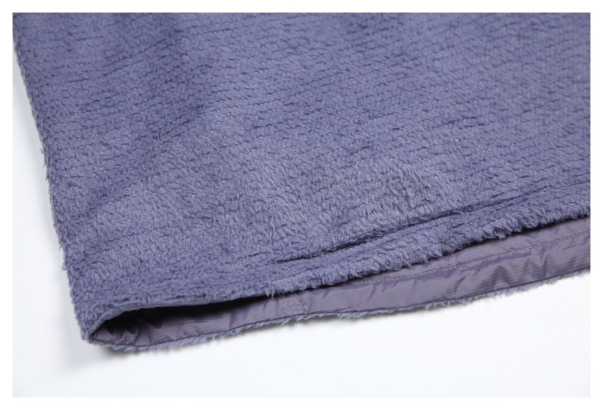 Close-up of the blue-gray fuzzy garment's folded hem and smooth inner lining.
