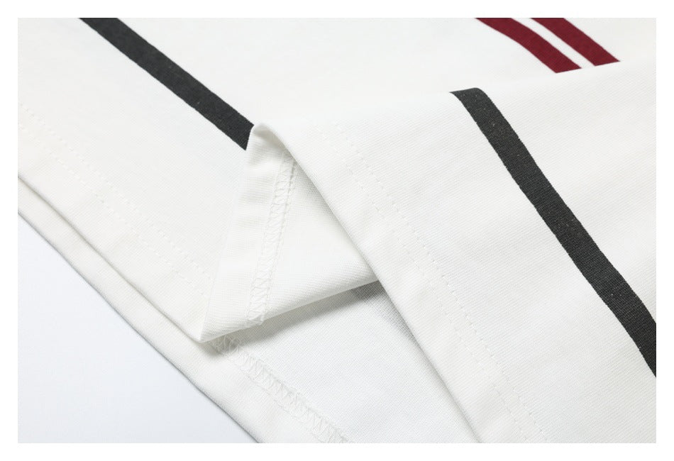 Close-up of white garment seam and folded edge with black and burgundy stripe details.